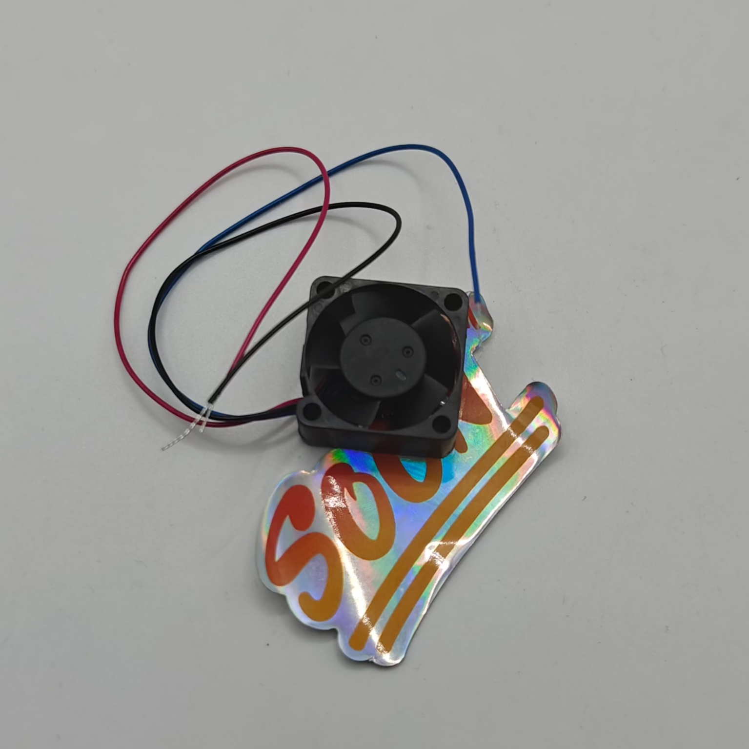 A small black Delta Electronics fan with three colored wires (red, blue, and black) attached.