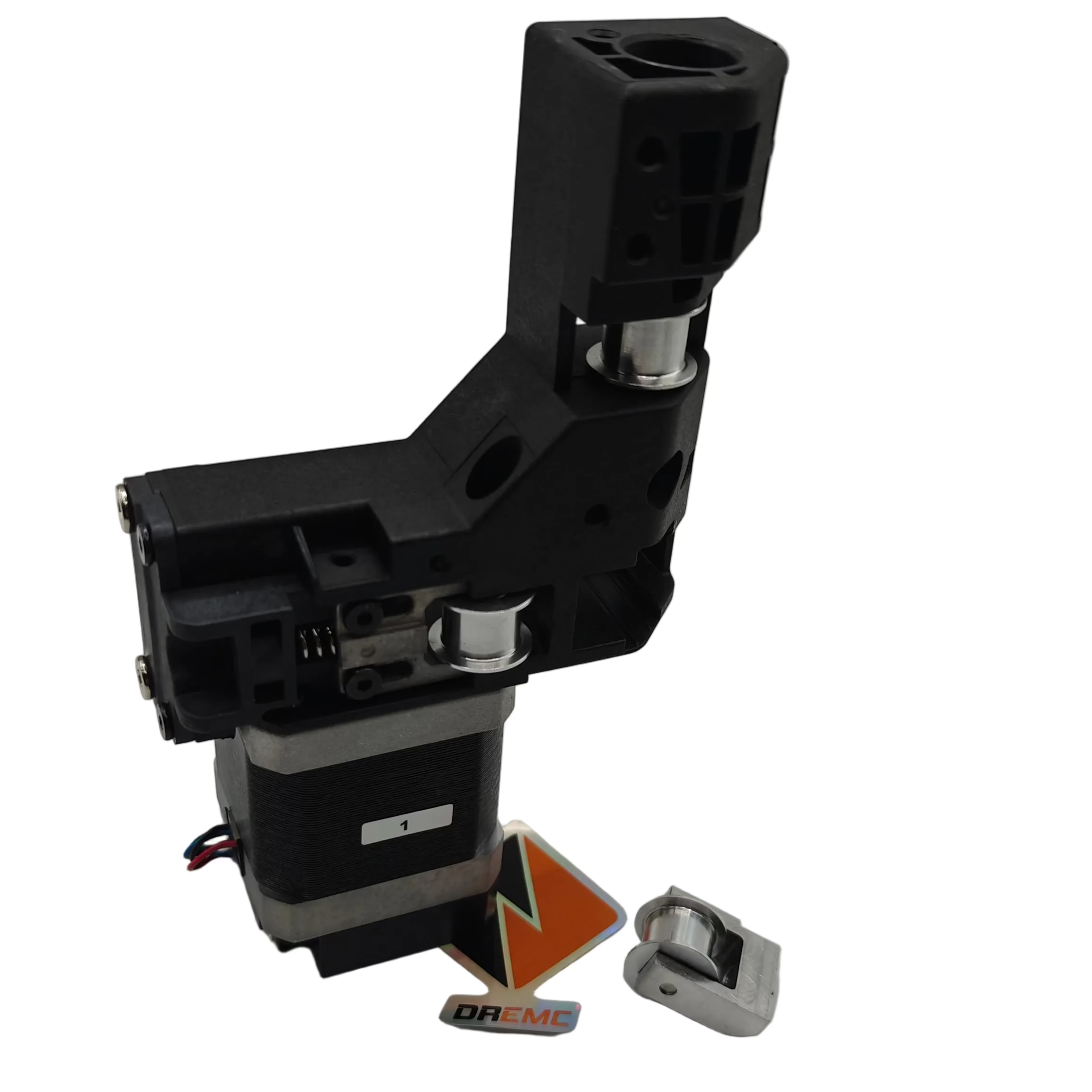A black and silver robotic arm end-effector assembly with a small orange-and-black logo tag and a small silver metal component on a plain light gray studio background.