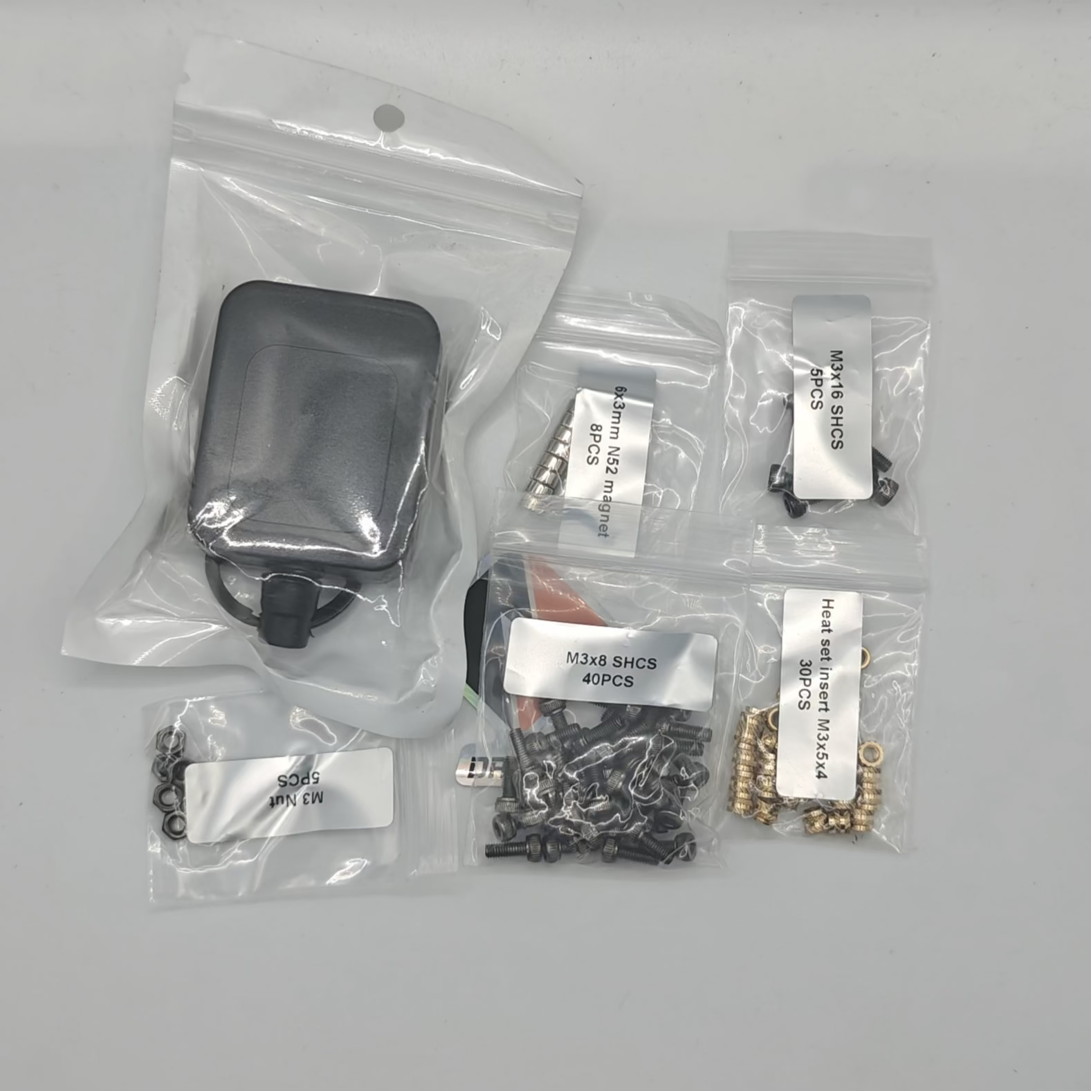Set of small electronic components in clear plastic bags on a white background