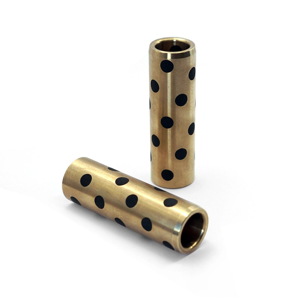 Two brass cylindrical components with black dot patterns on a white background